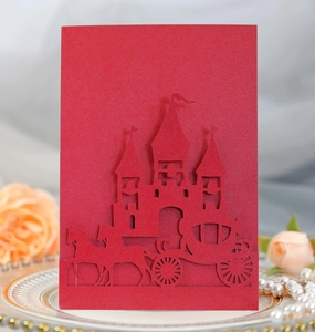 Macro shot of laser-cut wedding card featuring a European castle and carriage design