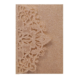 Macro detail of laser-cut lace floral pattern on rose gold glitter wedding invitation