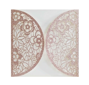 Detail of rose gold glitter wedding invitation featuring intricate laser cut floral patterns