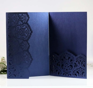 Macro shot of navy blue laser-cut floral wedding invitation with pearlescent finish