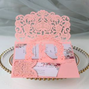 Détail du faire-part de mariage rose découpé au laser avec silhouette 3D et arche fleurie