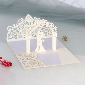 Detail of 3D laser-cut wedding card featuring a romantic couple under a heart arch