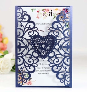 Detail of laser-cut navy blue pearlescent wedding invitation with floral insert and roses