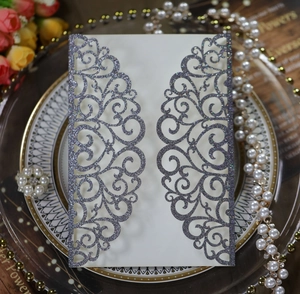 Intricate laser-cut wedding invitation cover with silver glitter floral patterns
