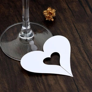 Close-up of white heart-shaped hollow paper place card on a wooden background