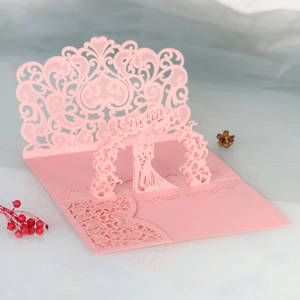 Détail d'une carte de mariage 3D avec silhouette de mariés découpée au laser rose
