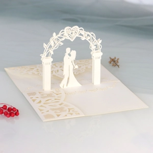 Detailed 3D laser cut wedding invitation card with kissing couple and lace heart arch