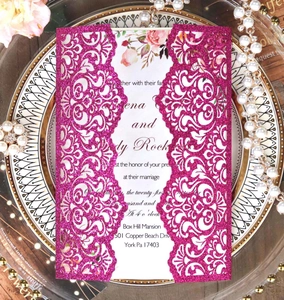 Detail of glitter rose pink laser cut wedding invitation with floral inner card