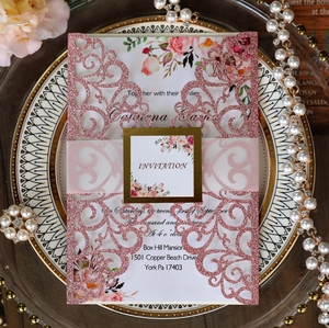 Elegant laser-cut wedding invitation with rose gold glitter and floral inner card