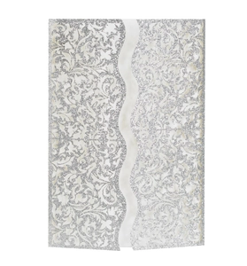 Detail of silver glitter laser-cut invitation cover with elegant symmetric floral pattern