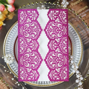 Detail showing glittery magenta laser-cut wedding invitation with damascus pattern