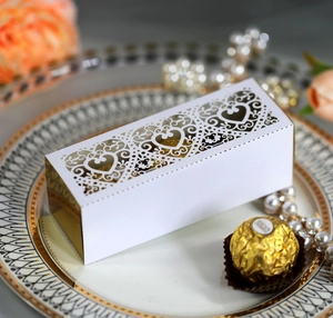 Detail of white heart laser-cut candy gift box with gold mirror sides and pearl decor