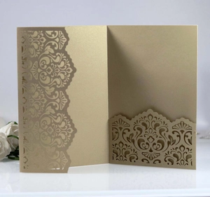 Macro detail of laser-cut champagne gold pearl paper wedding invitation with floral patterns