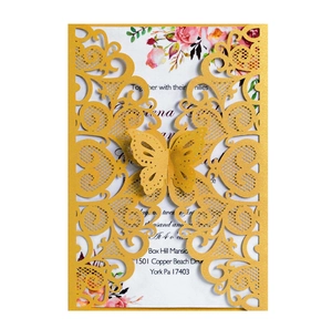 Detail of laser-cut gold butterfly pattern and floral inner card on wedding invitation