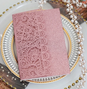 Detailed laser-cut floral lace and glitter coating on pink wedding invitation card