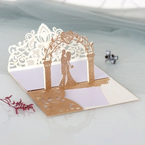 Détail macro de l'invitation de mariage 3D avec découpe laser et arche dorée scintillante