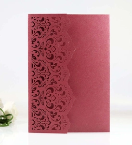 Detail of burgundy laser-cut invitation card with damascus pattern on pearlescent paper