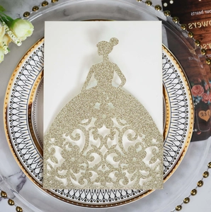Close-up of golden glitter laser-cut wedding invitation featuring elegant gown design
