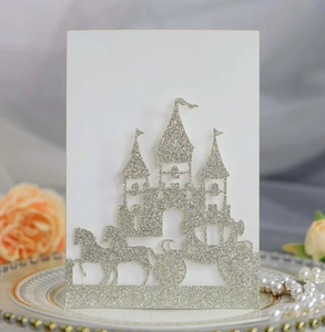 Detail of silver glitter laser cut wedding invitation with castle and carriage design