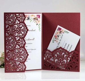 Macro detail of burgundy laser-cut floral wedding invitation set with RSVP cards