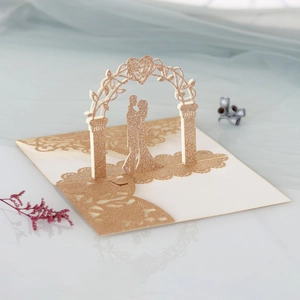 Carte de mariage 3D découpée au laser avec couple pailleté or champagne sous arche