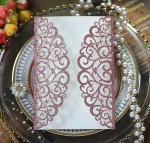 Detail of rose gold laser cut wedding invitation cover with floral patterns and glitter