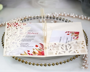 Detailed macro view of laser-cut wedding invitation featuring elegant vine patterns