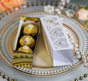 Detail of laser-cut heart pattern gift box with golden liner and three chocolate balls