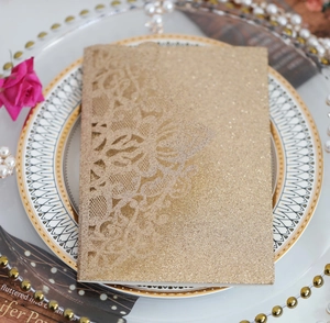 Détail de l'invitation de mariage en dentelle dorée découpée au laser sur une assiette