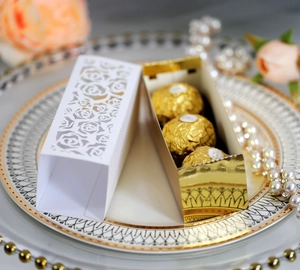 Detail of laser-cut rose hollow candy box with pearl texture and gold inner lining