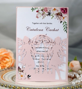 Detail of laser-cut pink wedding invitation featuring two fairies and castle silhouette