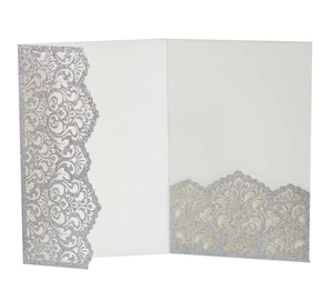 Detail of laser-cut wedding invitation with silver glitter floral patterns and cream liner