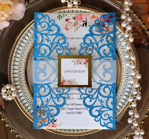 Macro view of laser-cut wedding invitation with glitter detail and floral inner card