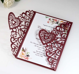 Macro detail of laser-cut burgundy heart invitation with elegant floral insert