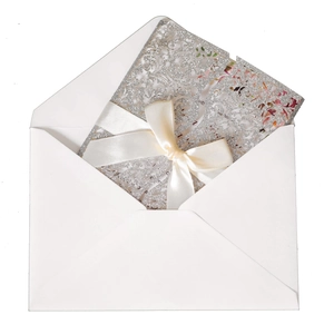 Detailed laser cut silver glitter wedding invitation with satin bow and floral inner card