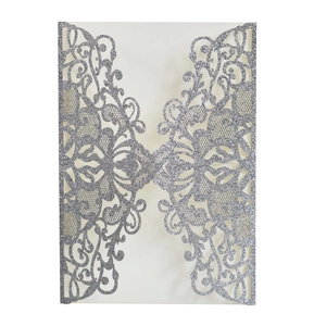 Macro detail of laser cut glitter wedding invitation with intricate silver lace patterns