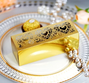 Macro detail of laser-cut heart pattern on golden chocolate gift box with metallic finish