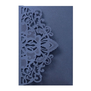Macro shot of dark blue laser-cut wedding invitation featuring intricate vine patterns