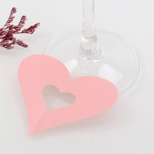 Detail of pink heart laser-cut card with elegant hollow design placed on a glass