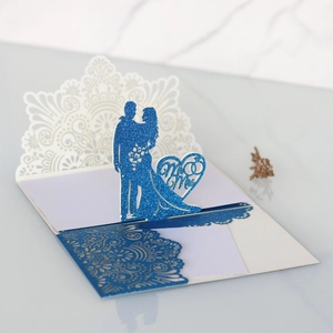 Dettaglio invito nozze blu glitterato con motivo a cuore Mr & Mrs intagliato al laser