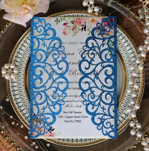 Macro view of blue glitter laser-cut wedding invitation with elegant floral insert card
