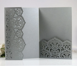 Macro detail of silver laser-cut wedding invitation with damask floral patterns