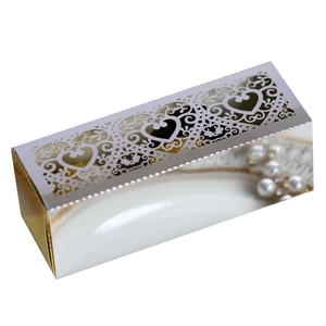 Detail view of silver laser-cut heart pattern gift box with golden silk lining and pearl