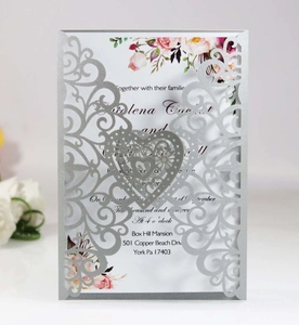 Detailed laser-cut silver wedding invitation with heart pattern and floral inner page