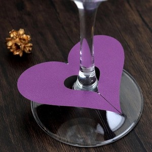 Macro detail of purple heart-shaped laser cut card placed on a wine glass stem