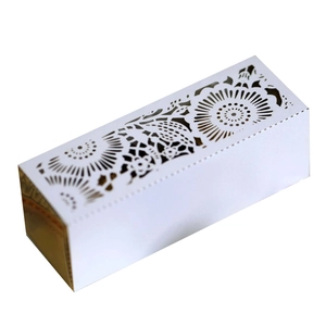 Detail of laser-cut white wedding favor box showing intricate floral mandala patterns