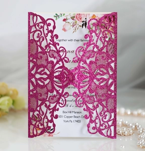 Detail showing magenta glitter laser-cut invitation cover with elegant lace butterfly patterns