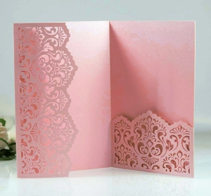 Detail of pink pearlescent laser-cut invitation card with floral pocket for weddings