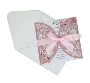 Detailed laser cut wedding invitation with glitter cover, pink ribbon, and inner card