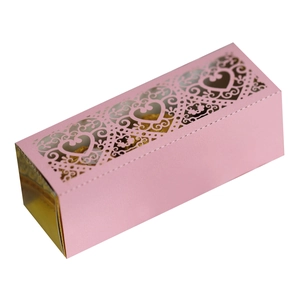 Detail of pink laser-cut heart hollow gift box with golden chocolates inside